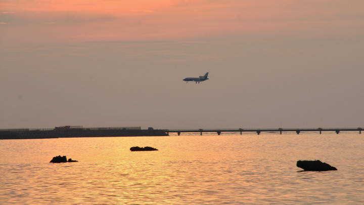 佐和田の浜展望台から眺める夕日と飛行機